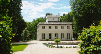 Biały Dom w Łazienkach Królewskich w otoczeniu drzew.
