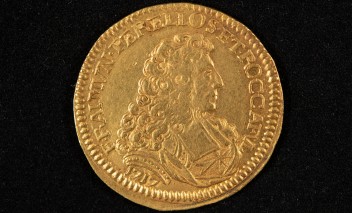 Stara, złota moneta przedstawiająca popiersie mężczyzny. 