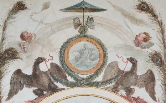 Malowidło przedstawiające dwa ptaki, trzymające w dziobach wieniec z liści, który jest owinięty wokół koła, nad którym latają dwa motyle. Po bokach widoczne są pawie pióra.