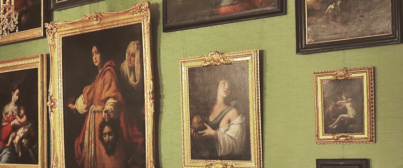 Galeria Obrazów w Pałacu na Wyspie. Obrazy z kolekcji króla Stanisława Augusta w złotych ramach wiszą na jasnozielonej ścianie. 