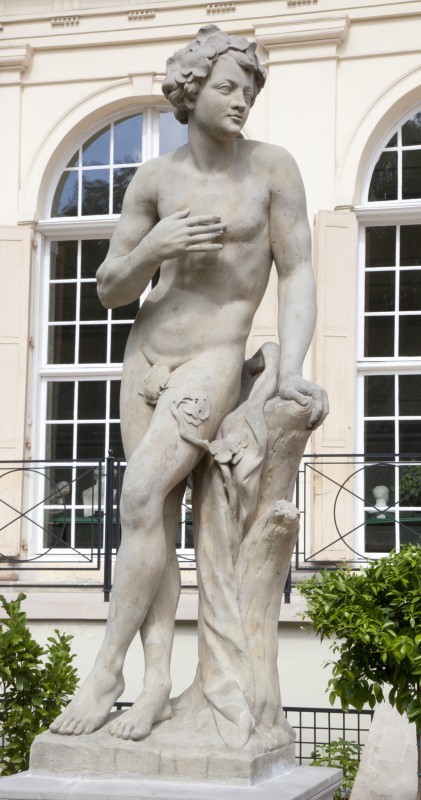 Rzeźba przedstawiająca stojącego, nagiego mężczyznę. 