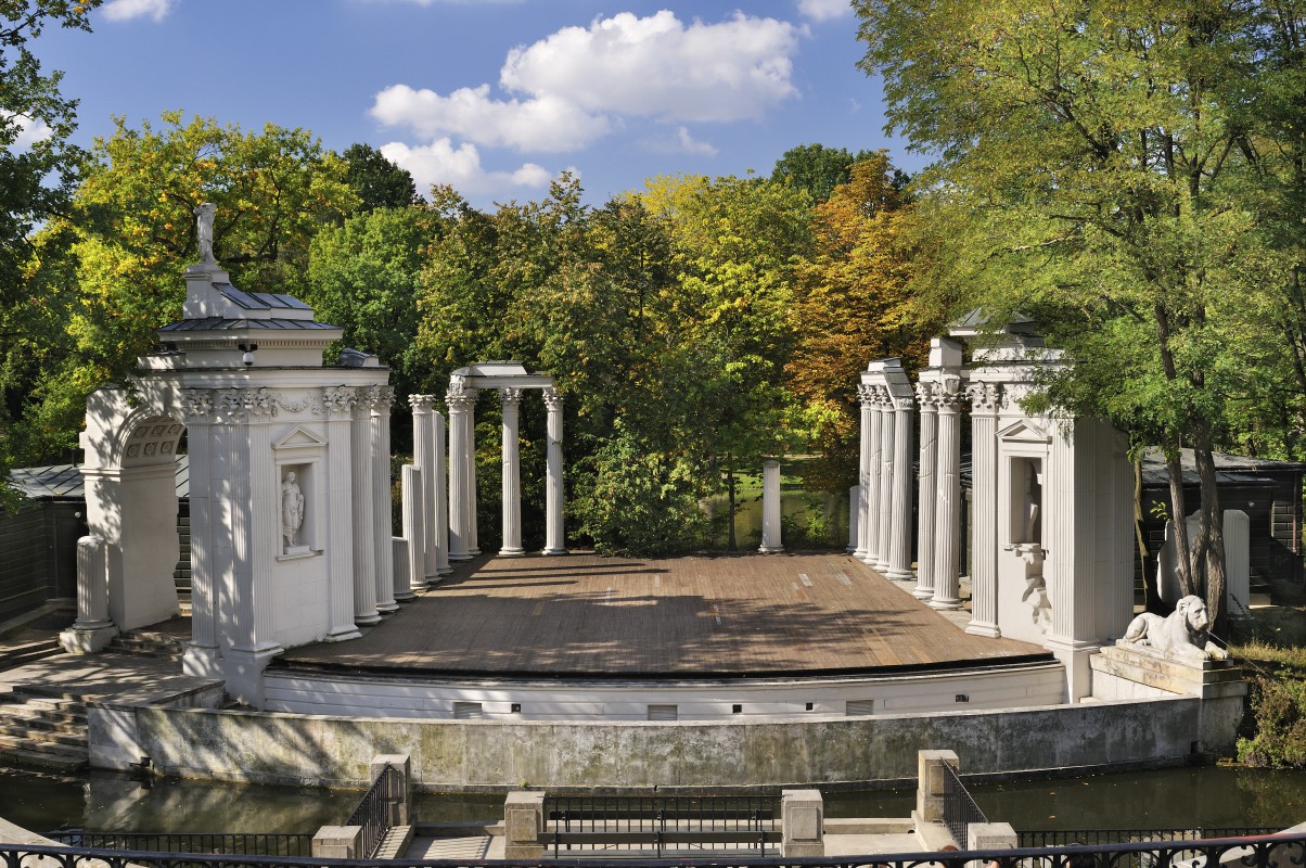 Amfiteatr w Łazienkach Królewskich w otoczeniu drzew.