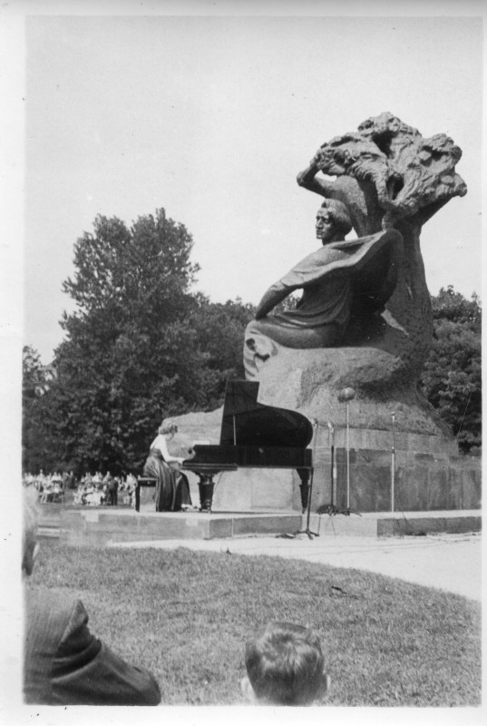 Koncert pod Pomnikiem Chopina, kobieta gra na fortepianie pod monumentem Fryderyka Chopina.