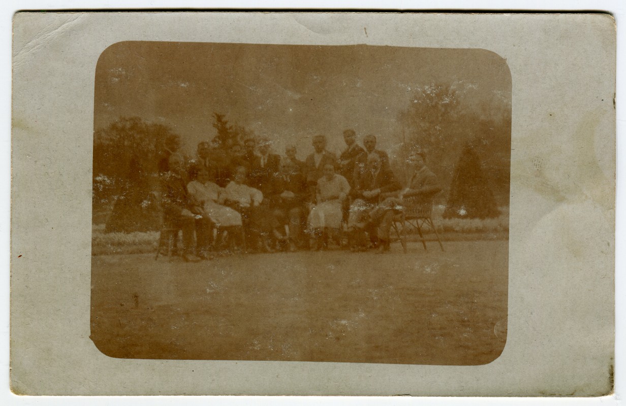 Archiwalna fotografia przedstawiająca grupę osób pozujących do zdjęcia.