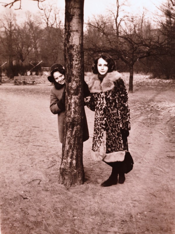 Dwie kobiety stoją przy drzewie. 