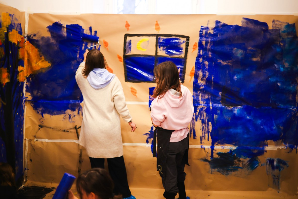 Dzieci malują na ścianie obrazy. 