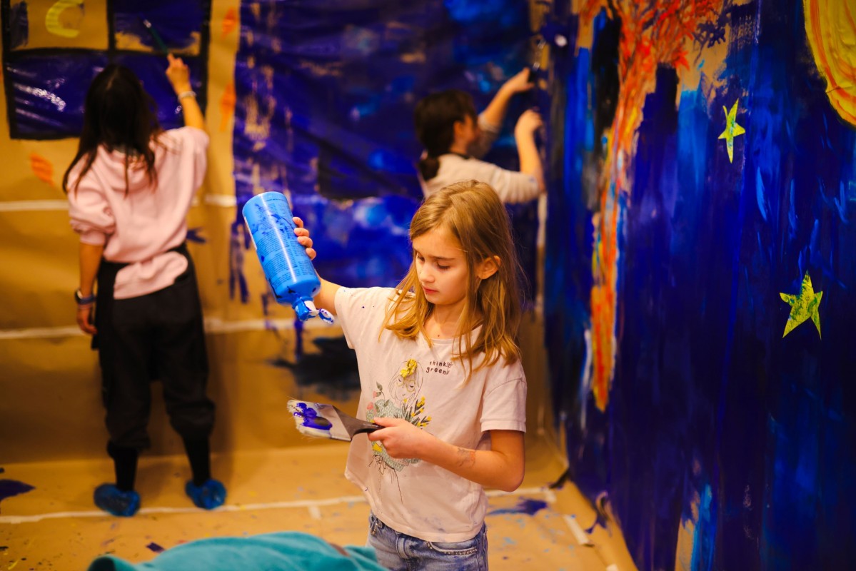 Dzieci malują na ścianie obrazy.