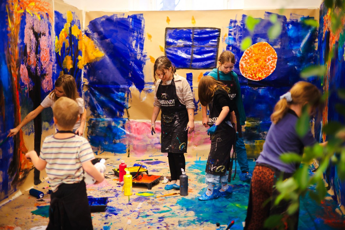 Dzieci malują na ścianie obrazy.