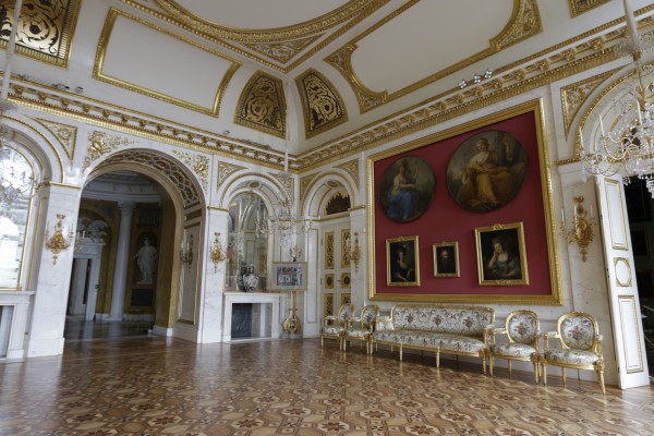 Sala Salomona w Pałacu na Wyspie. Na środku widoczne jest łukowate przejście, na ścianie, po prawej, wiszą obrazy i stoją krzesła oraz kanapa.