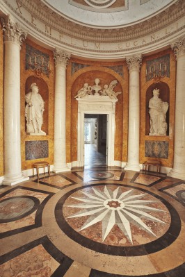 Rotunda w Pałacu na Wyspie, pod ścianą znadują się kolumny i posągi przedstawiające dwóch królów.