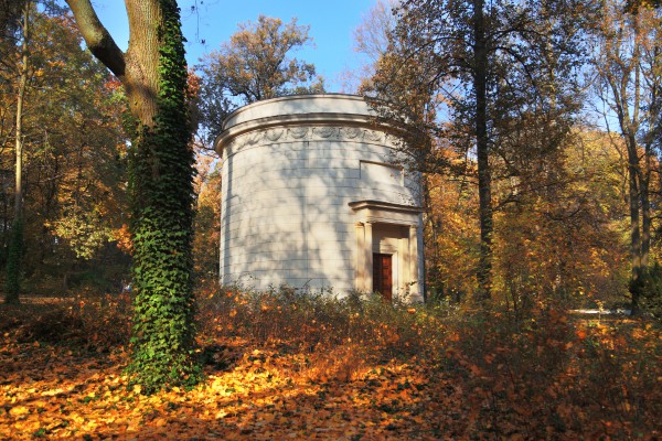 Wodozbiór w Łazienkach Królewskich - okrągły biały budynek, na środku drzwi z kolumnowym portykiem.