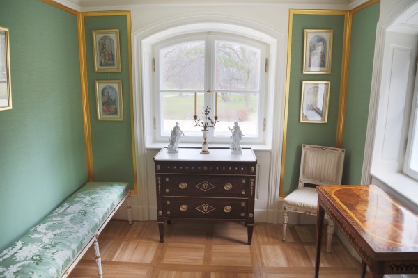 Gabinet z komodą, krzesłem i stolikiem, na ścianach wiszą obrazy. 
