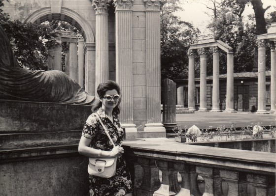 Kobieta stojąca na tarasie widokowym, z tyłu wiadać kolumny Amfiteatru w Łazienkach Królewskich.