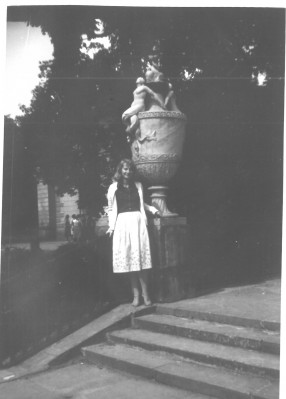 Kobieta stojąca na schodach przy rzeźbie przedstawiającej kielich. 
