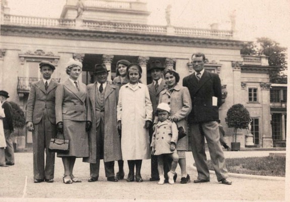 Grupa osób stojąca przed Pałacem na Wyspie w Łazienkach Królewskich.