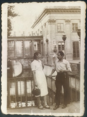 Kobieta i mężczyzna stoją na mostku przy Pałacu na Wyspie w Łazienkach Królewskich. 