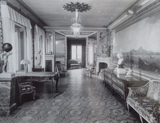 Archiwalne zdjęcie królewskiego gabinetu, w którym przy ścianach stoją zabytkowe meble: kanapy, biurka.
