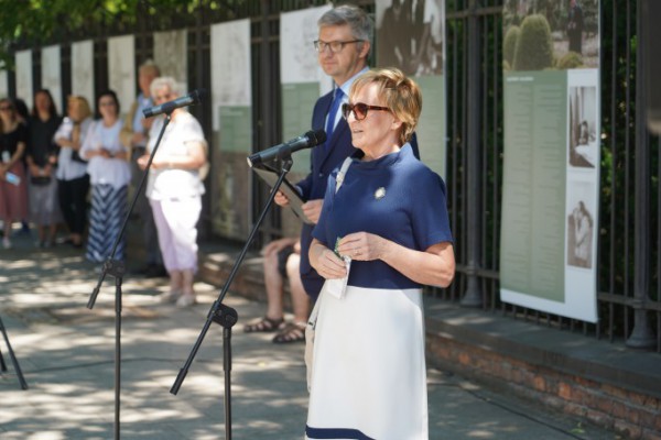 Kobieta stoi przed mikrofonem.
