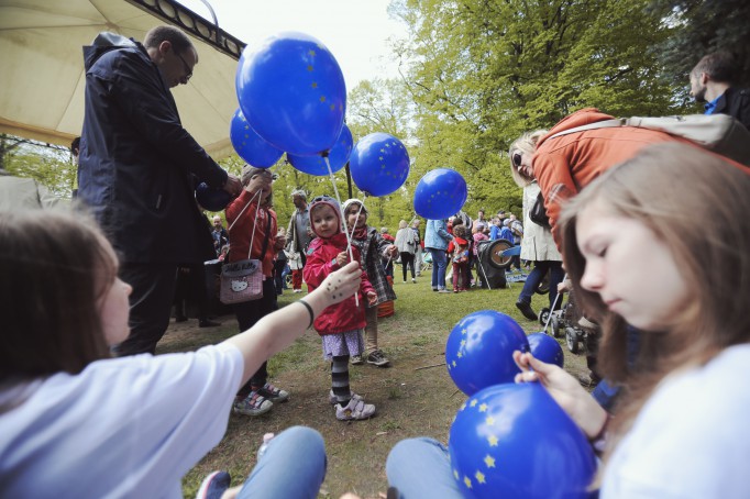 Dzieci na pikniku z niebieskimi balonami.