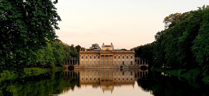 Pałac na Wyspie w otoczniu wody i drzew.