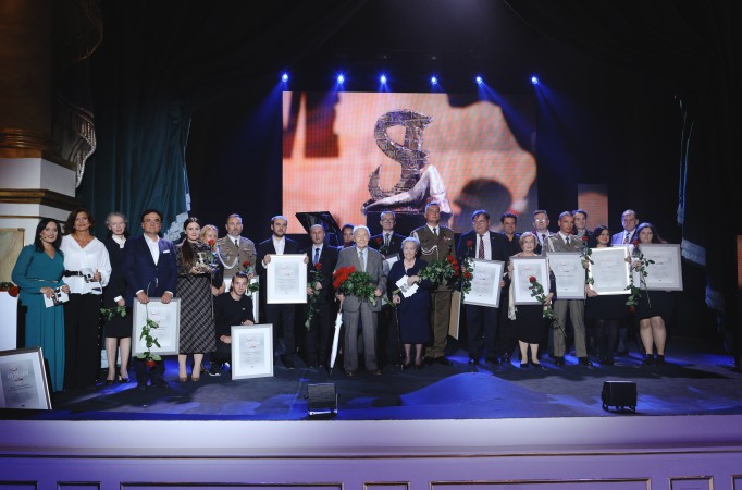 Laureaci nagrody "Wawa Bohaterom" stoją na scenie, trzymając dyplomy i nagrody. 