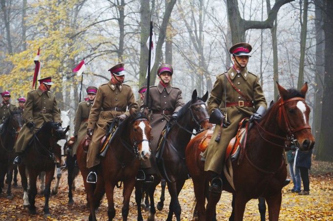 Kawalerzyści jadący na koniach w ogrodach Muzem Łazienki Królewskie.