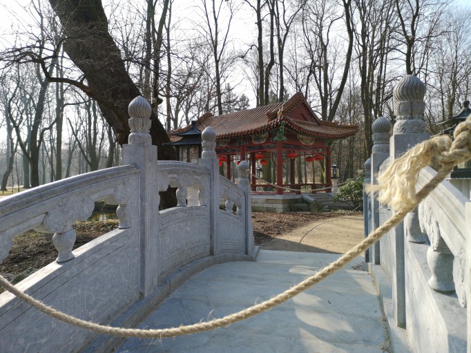 Mostek chiński przewiązany liną, w tle widoczna jest chińska altana.