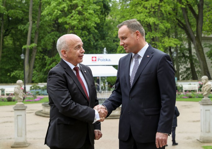 Prezydent Szwajcarii i prezydent Polski stoją i ściskają sobie dłonie.