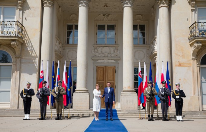 Prezydent Słowacji Zuzanna Čaputová i premier Mateusz Morawiecki stoją przed Pałacem na Wyspie, ściskając sobie dłonie, po lewej i prawej stronie warta honorowa.