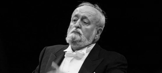 Krzysztof Penderecki na czarno-białym zdjęciu, w smokingu. 