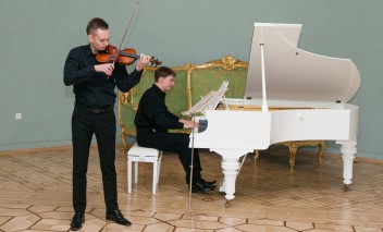 Koncert, podczas którego jeden mężczyzna gra na fortepianie, a drugi na skrzypcach. 
