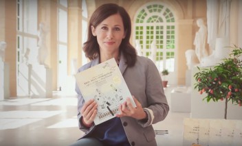 Aktorka Jolanta Fraszyńska siedzi w Starej Oranżerii i trzyma przed sobą książkę.