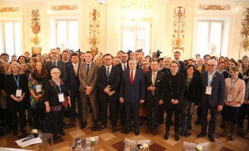 Grupa kilkudziesięciu osób stoi w Sali Balowej w Pałacu na Wyspie.