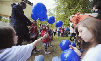 Dzieci na pikniku z niebieskimi balonami.