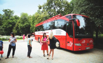 Dwie kobiety stoją przed autobusem.