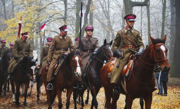 Kawalerzyści jadący na koniach w ogrodach Muzem Łazienki Królewskie.