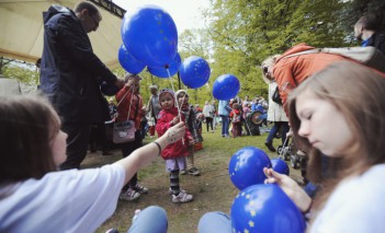 Dzieci na pikniku z niebieskimi balonami.