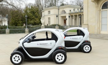 Czarno-białe samochody elektryczne przed Pałacem na Wyspie.