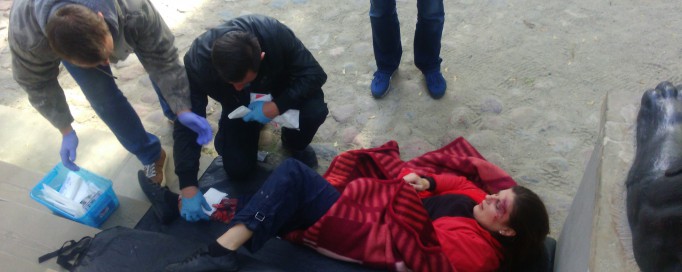 Leżącemu człowiekowi udzielana jest pierwsza pomoc.