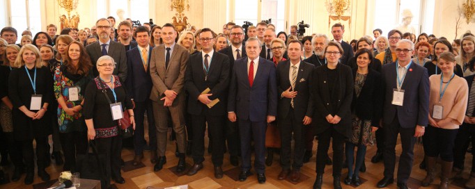 Grupa kilkudziesięciu osób stoi w Sali Balowej w Pałacu na Wyspie.