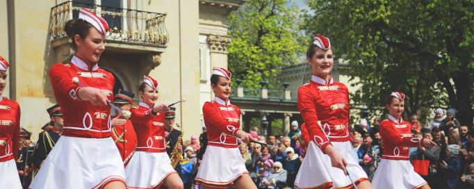 Parada przed Pałacem na Wyspie. Kobiety ubrane w biało-czerwone stroje maszerują. 