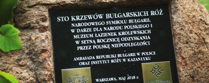 Tablica pamiątkowa z napisami wmurowana w kamień.
