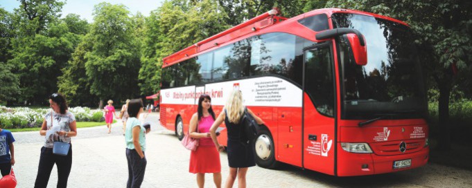 Dwie kobiety stoją przed autobusem.