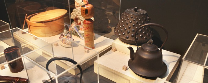 Wystawa japońskich przemiotów użytkowych, w gablotach widoczne są czajniki i japońskie lalki.