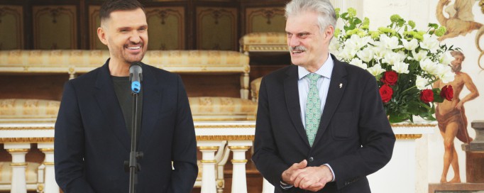 Jeden z mężczyzn, projektant Maciej Zień, stoi przed mikrofonem, drugi - dyrektor Muzeum Łazienki Królewskie - obok.