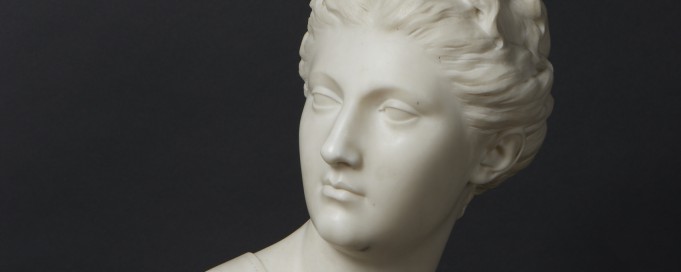 Rzeźba przedstawiająca popiersie antycznej bogini Diany, wykonana z marmuru, ukazana na na ciemnym tle.