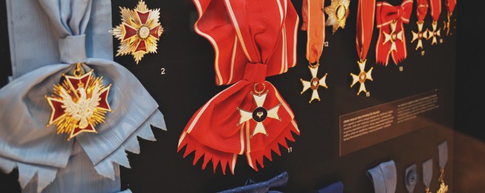 Ordery wiszące na błękitnych i czerwonych wstęgach.