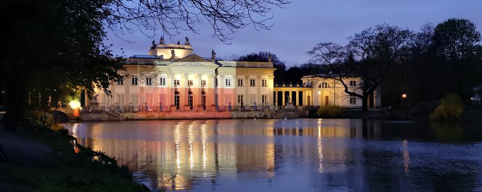 Pałac na Wyspie nocą, oświetlony iluminacją w biało-czerwonych barwach.