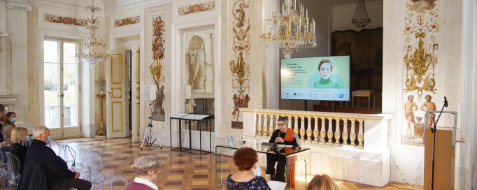 Wykład w Sali Salomona w Pałacu na Wyspie. Przed słuchaczami siedzi wykładowczyni. 