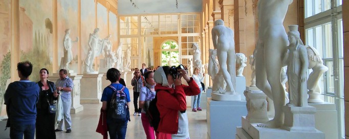Zwiedzający w Królewskiej Galerii Rzeźby oglądają marmurowe posągi. 